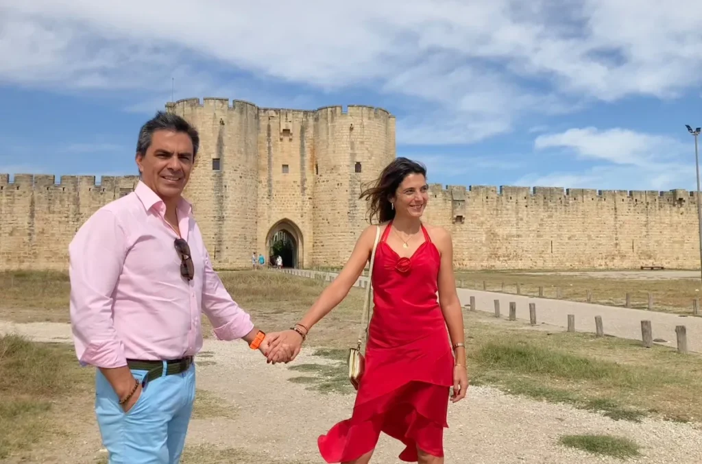 Fotografía de diegoenfrance.com: pareja caminando hacia las murallas históricas de Aigues-Mortes, un ícono del turismo en la Camarga