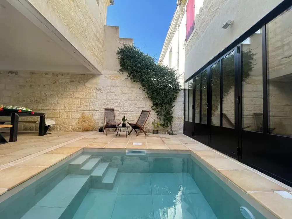 Pequeño hotel boutique con piscina privada y muros de piedra, en el centro histórico.