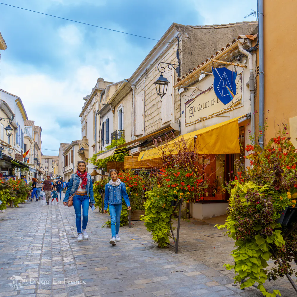 Calle peatonal llena de color, tiendas locales y vida en el centro histórico de Aigues-Mortes. Fotografía de diegoenfrance.com