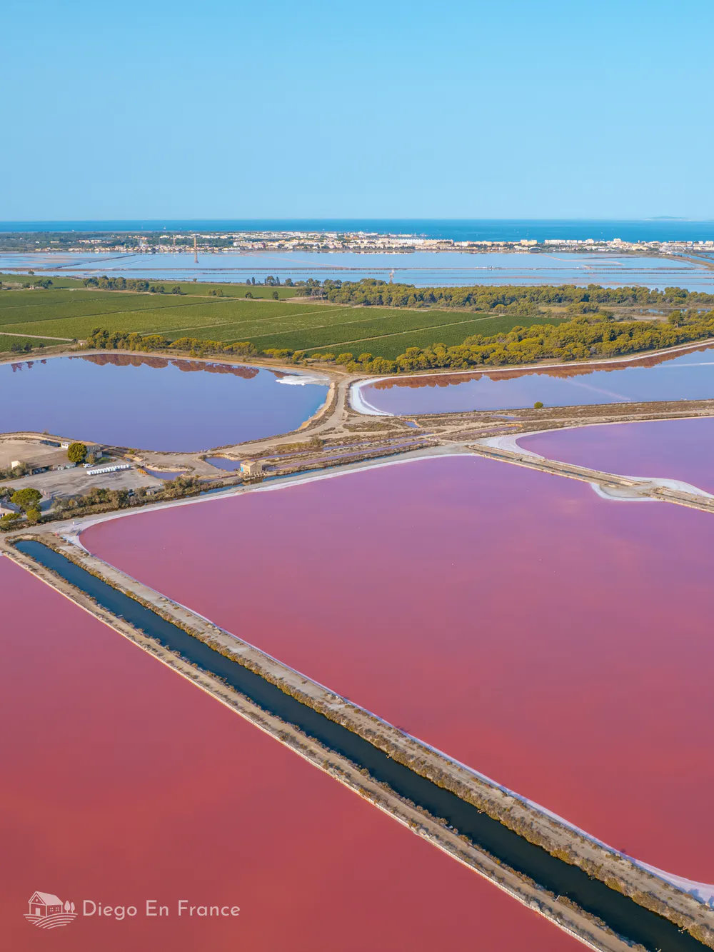 Vista aérea de las salinas rosadas que rodean Aigues-Mortes, destino imprescindible en la Camarga. Fotografía de diegoenfrance.com