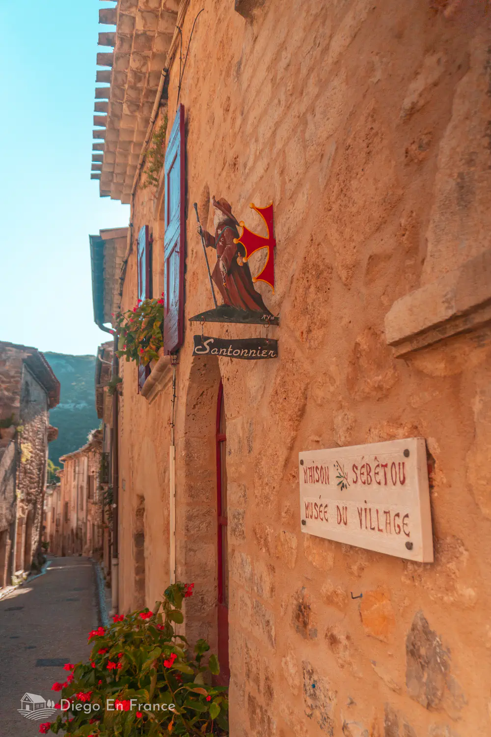 Fachada de casa de piedra con cartel del Museo del Village d’Antan