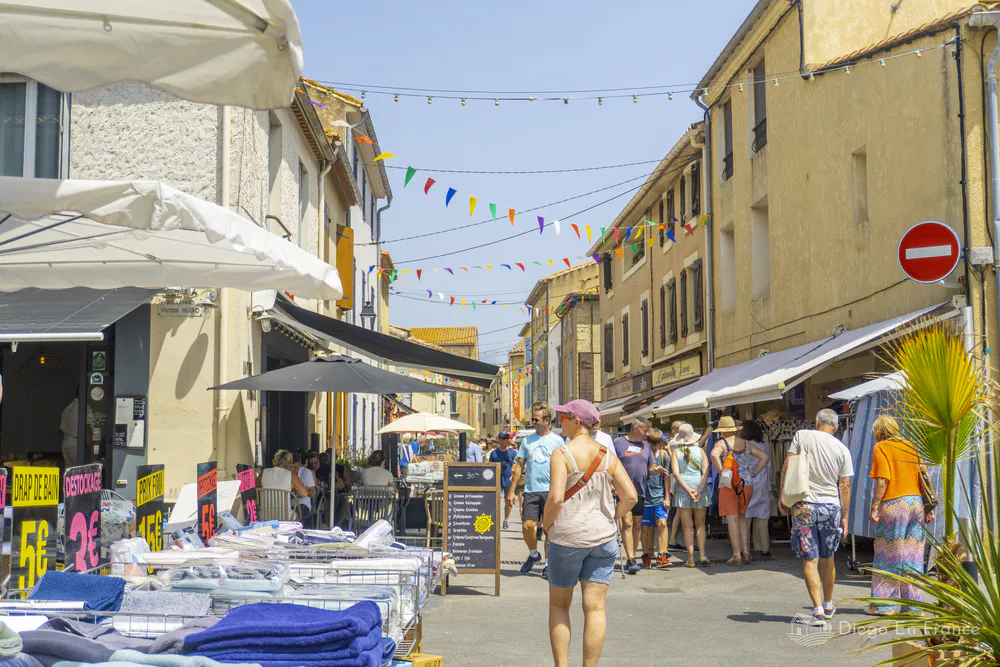 Fotografía de diegoenfrance.com del mercado callejero de Gruissan con puestos y turistas recorriendo.