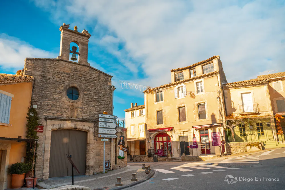 Picturesque square in Gordes, Provence, with its stone church and typical facades of the region, reflecting the charm of the medieval village.