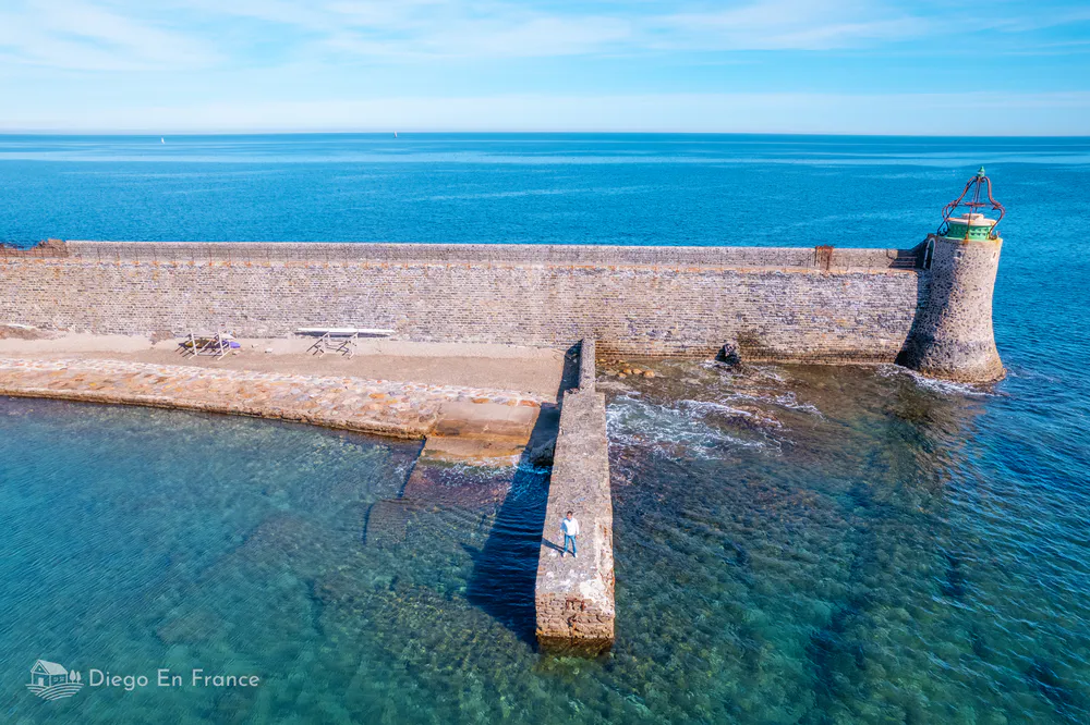 Landscape of the rocky coast of Collioure with the deep blue sea in the background.