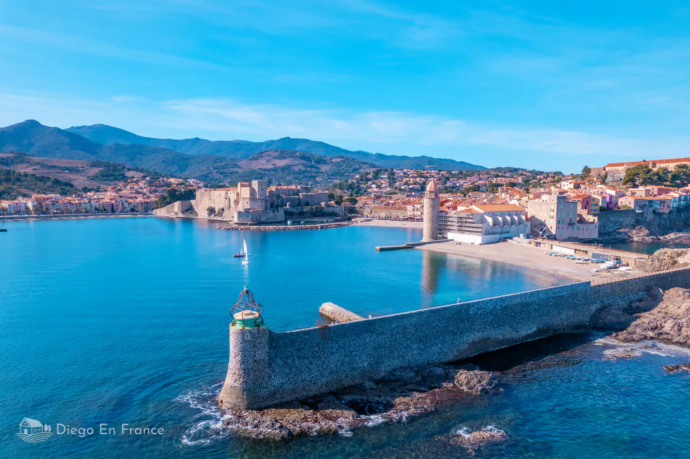Panoramic view of the port of Collioure with colorful boats floating on the water.