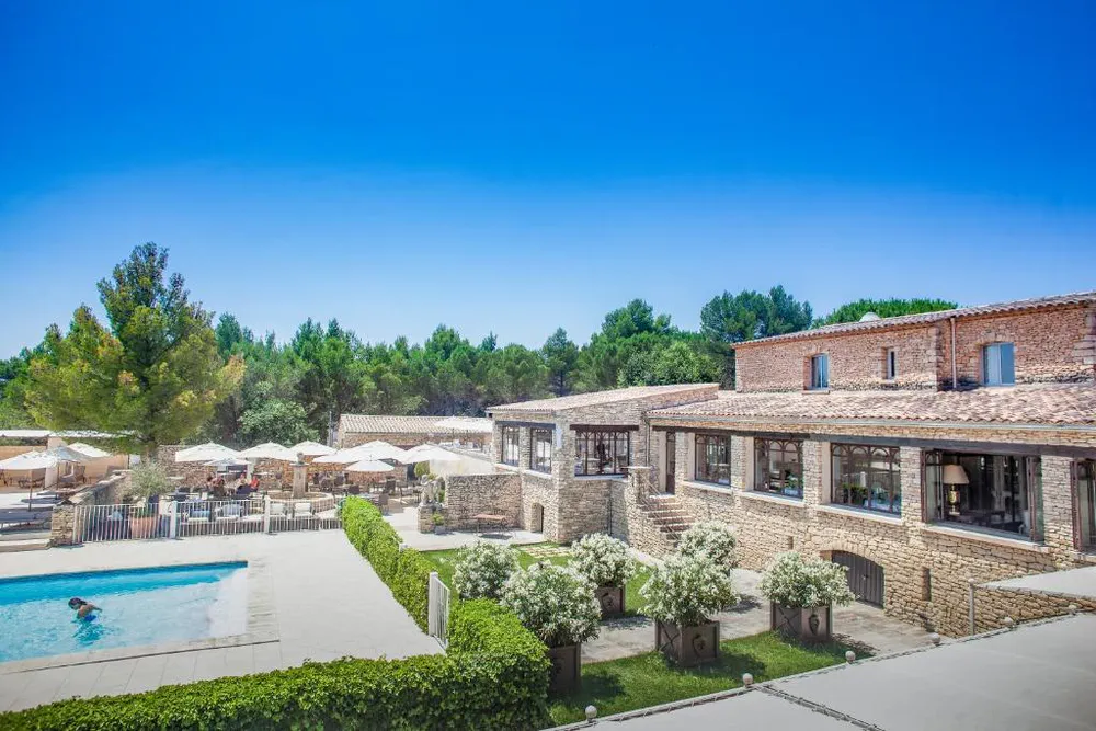 Swimming pool and facade of Le Phébus, Relais & Châteaux hotel in the heart of Luberon