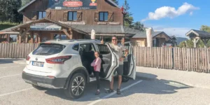 Un padre e hija entrando al coche en un parador al lado de las carreteras francesas.