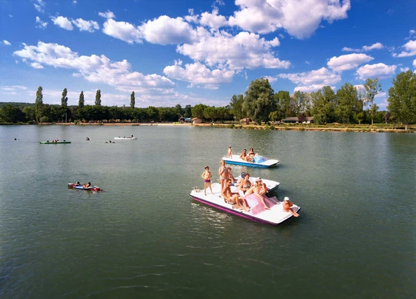 Families pedal boating on the lake, perfect recreation plan near the village
