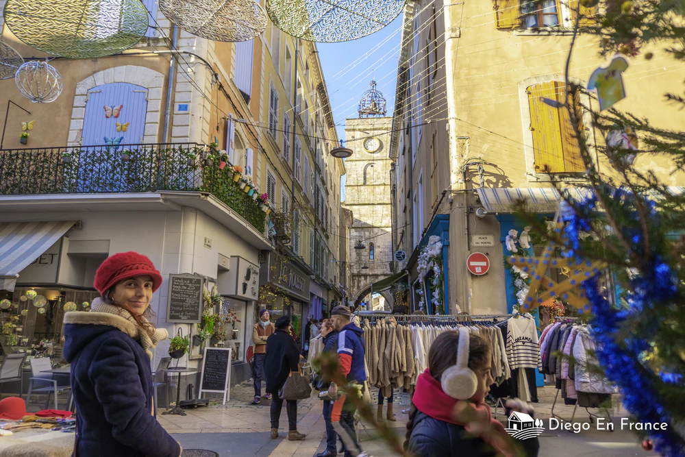 Decoraciones navideñas y visitantes entre tiendas y puestos típicos en una ciudad provenzal. Fotografía de diegoenfrance.com