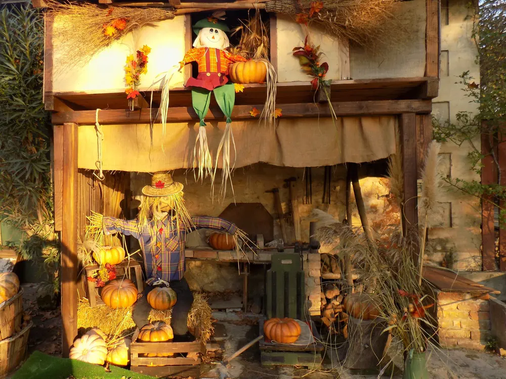 Montaje rústico con elementos de cosecha y espantapájaros en una escena de granja típica.