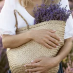 Mujer con una canasta llena de flores de lavanda, en un campo en la Provenza