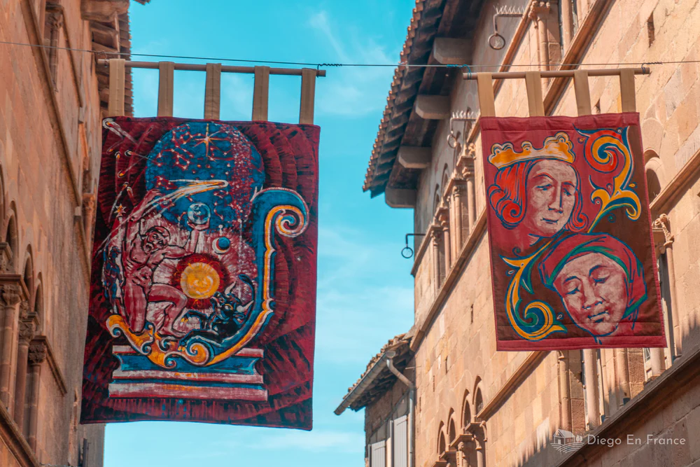 Banderas decorativas medievales colgadas entre edificios de piedra