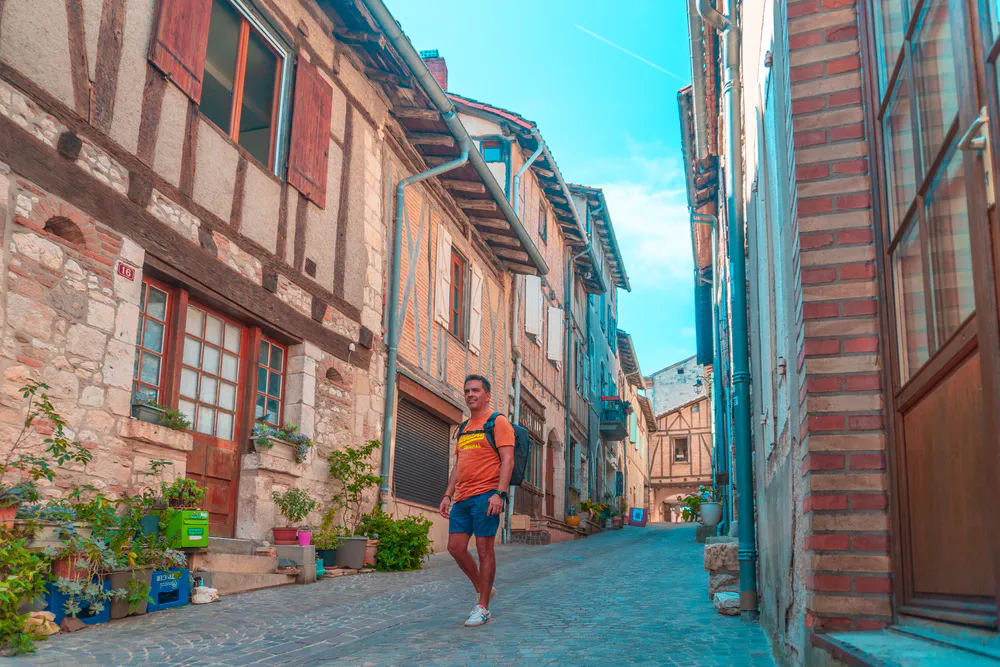 Tourist walking along a cobblestone street of the village, discovering its medieval essence.