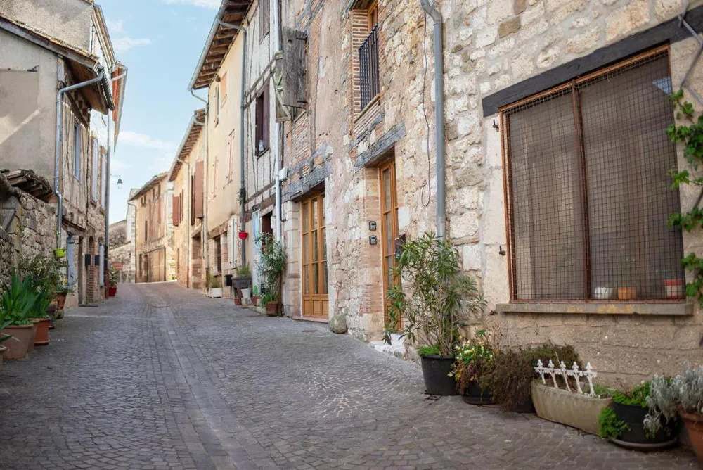View of cobblestone street and historic houses in the old town of Castelnau-de-Montmiral