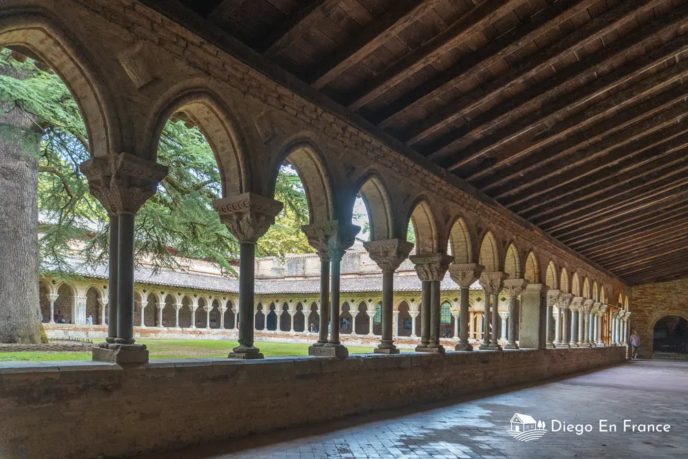 Porticoed gallery with stone arches surrounding a landscaped courtyard