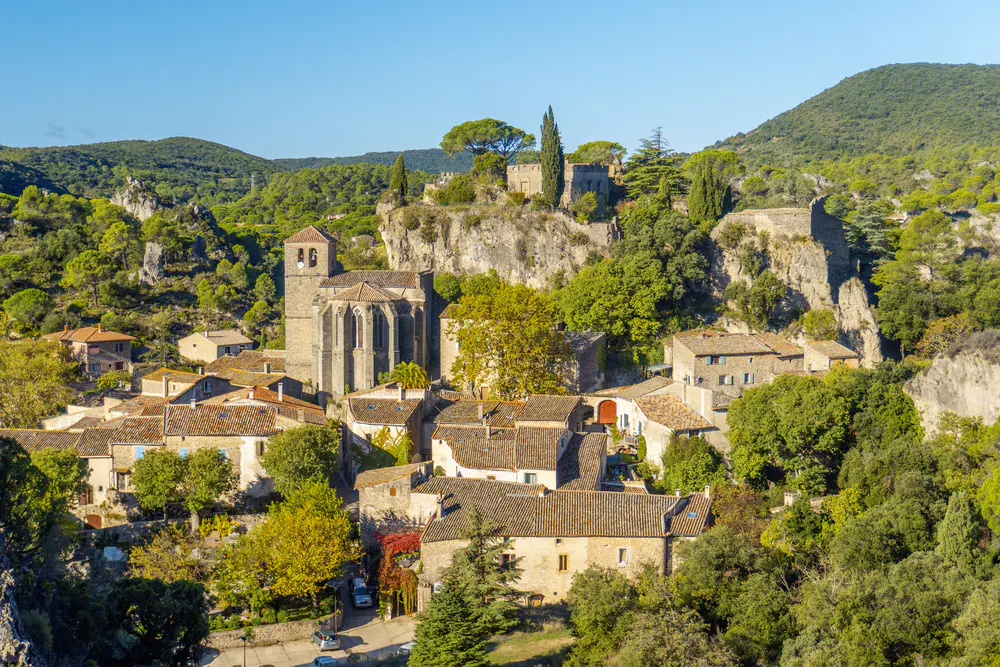 Aerial view of village with church, stone houses, and mountainous terrain