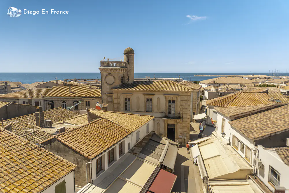 Roofs of houses by the sea with historic tower and clear sky