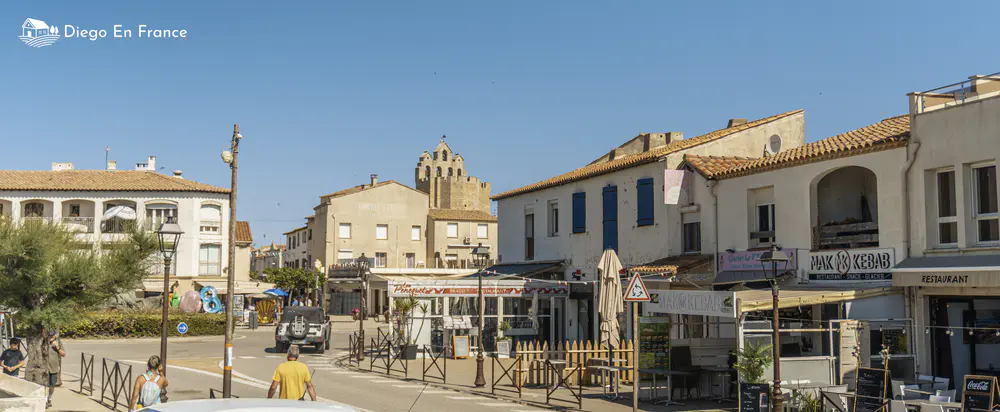 Urban street with terraces, shops, and pedestrians in a coastal town in the south of France