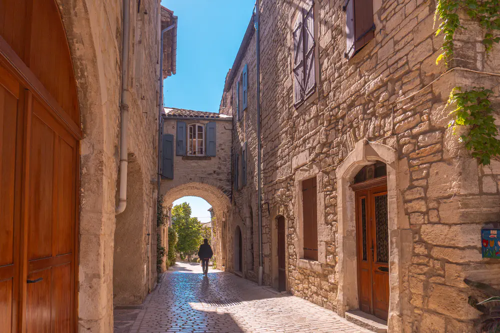 Stone street with an arch and historic buildings in a historic village in southern France