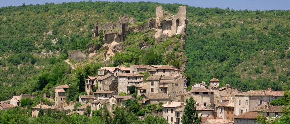 Panoramic view of Penne, a medieval hilltop village with its historic fortress surrounded by nature.