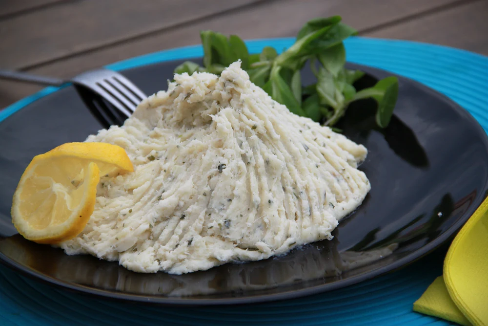 Brandade de morue servie à la manière traditionnelle de Nîmes, avec du citron et des herbes.