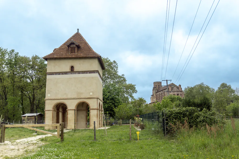 Historic dovecote of the Tarn in a rural setting, with the Saint-Alain cathedral visible in the distance.