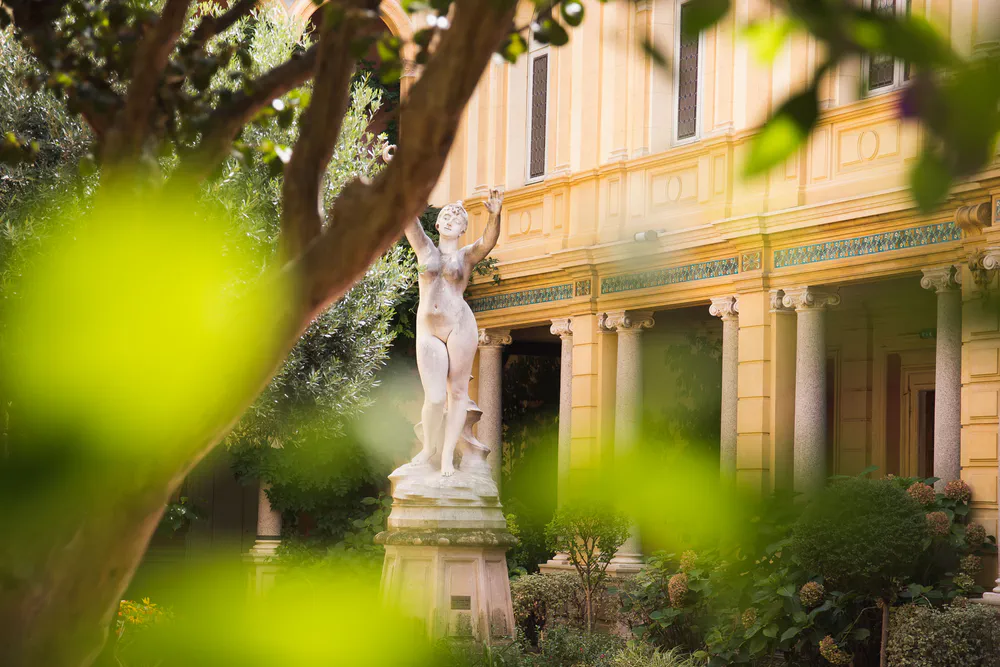 Hôtel Pams en Perpiñán, con su elegante fachada y jardín interno, perfecto para los amantes de la historia y el arte