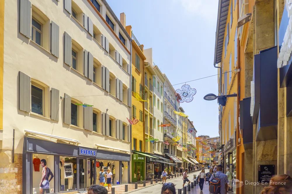 Fotografía de diegoenfrance.com de una calle peatonal con tiendas y fachadas típicas en Perpiñán