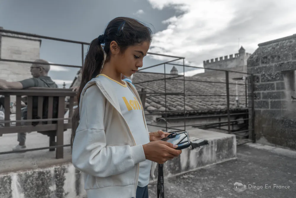Fotografía de diegoenfrance.com de una niña usando el Histopad en el Palacio de los Papas, ideal para descubrir qué ver en Aviñón en familia