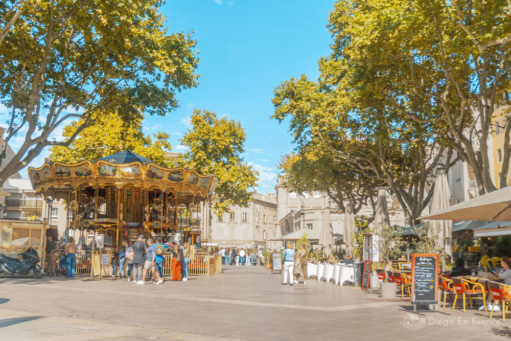 Fotografía de diegoenfrance.com de la plaza principal con su carrusel y cafés, ideal para quienes buscan qué hacer en Aviñón en familia